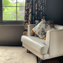 Load image into Gallery viewer, Butterfly print in grey, yellow and beige neutrals printed on square linen designer handmade cushion on leather armchair in room with chocolate walls at Parma farm stay Nowra