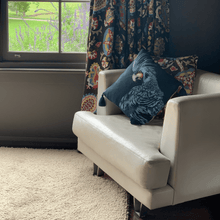 Load image into Gallery viewer, black cockatoo printed on indigo square linen designer handmade cushion on leather armchair in room with chocolate walls at Parma farm stay Nowra