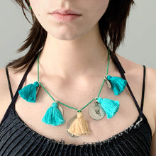 Load image into Gallery viewer, Ethically sourced Old Fashioned Online green beaded necklace with Turquoise tassels and five silver amulet charms on girl wearing blue denim