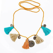 Load image into Gallery viewer, Ethically sourced Old Fashioned Online orange beaded necklace with beige and orange and turquoise tassels and five silver amulet charms on flat lay