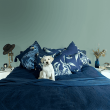 Load image into Gallery viewer, Guide dog puppy in blue bed with black cockatoo printed on indigo square linen designer cushion with tassels handmade in Australia