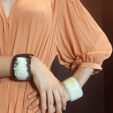 Load image into Gallery viewer, A picture of a girl wearing a peach dress and large horn bangles on her arms while resting her hands on one hip