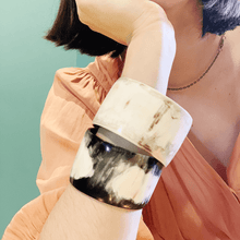 Load image into Gallery viewer, A picture of ebony and ivory coloured bone bangles on a girls arm