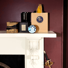 Load image into Gallery viewer, picture of candle and gifts on a fire place mantle in a burgundy room