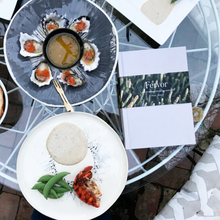 Load image into Gallery viewer, A picture of Fervor cook book on a table next to oysters with finger lime  and cooked Aaron on decorative monochrome plates
