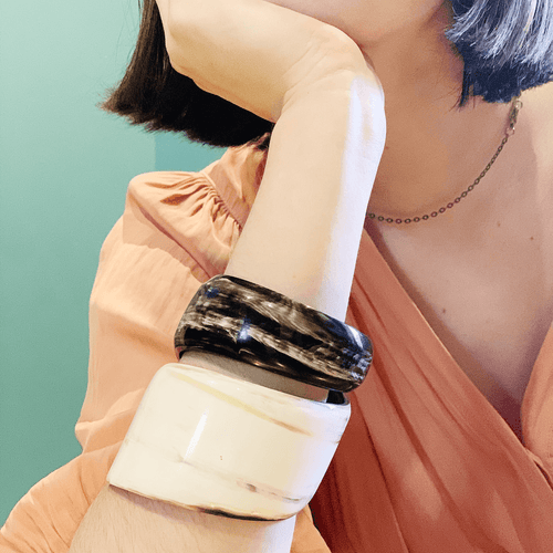 girl in peach dress wearing large horn bracelet and simple gold chain