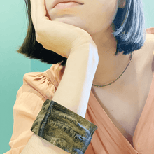 Load image into Gallery viewer, girl in peach dress wearing natural buffalo  horn bracelet  and a simple gold chain
